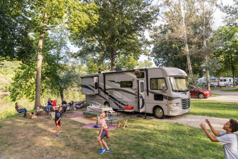 kids playing in front of an RV at a campground