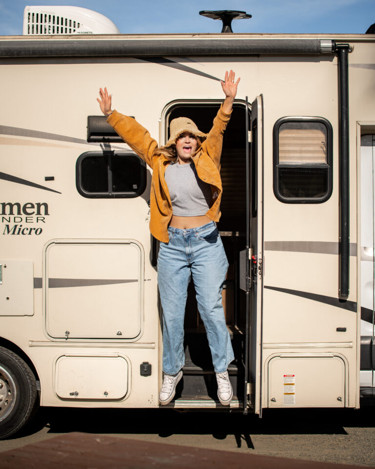 a woman jumping out of the door of her RV