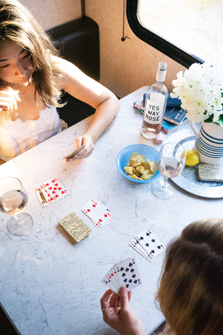 girls at an RV dining table playing cards