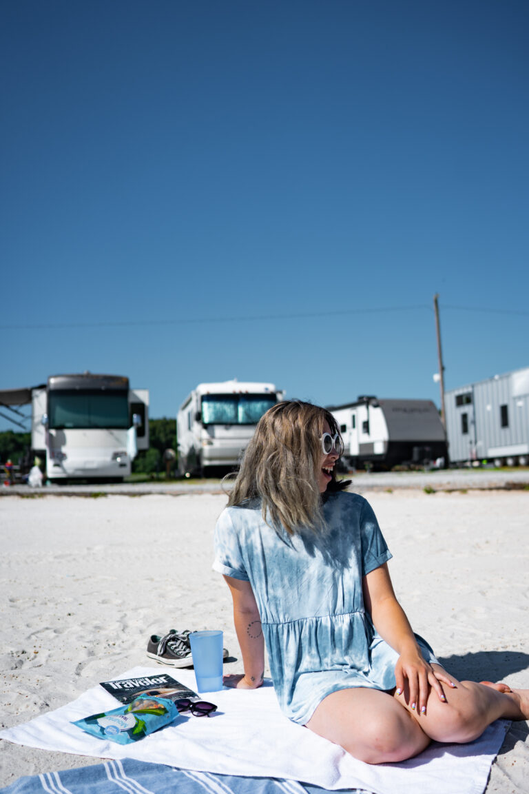 a woman on a beach in front of several RVs