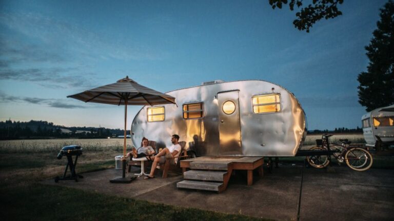 People sitting outside of an RV rental at dusk