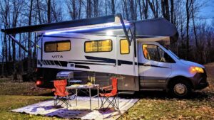 RV sitting in campsite at dusk with RV awning replacement extended