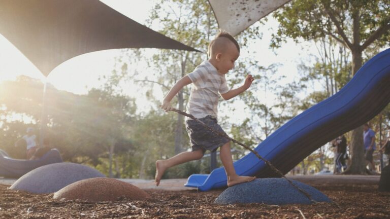 Little boy running on playground at kid-friendly campground