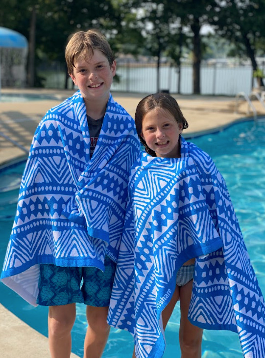 kids next to a campground pool wrapped in towels