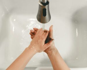 Person washing hands under RV faucet