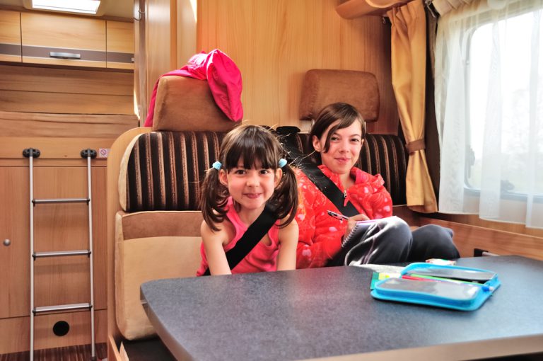 two children sit at the table in an RV