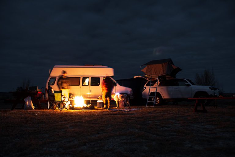 Campfire just outside a campervan