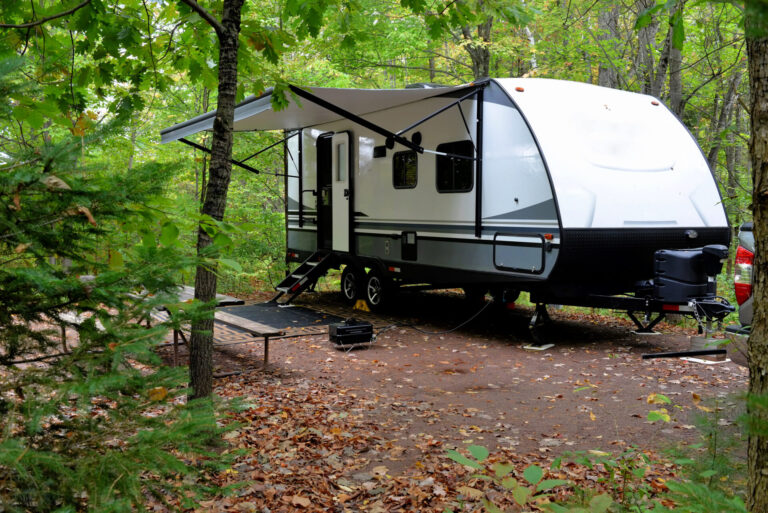 travel trailer set up in the woods