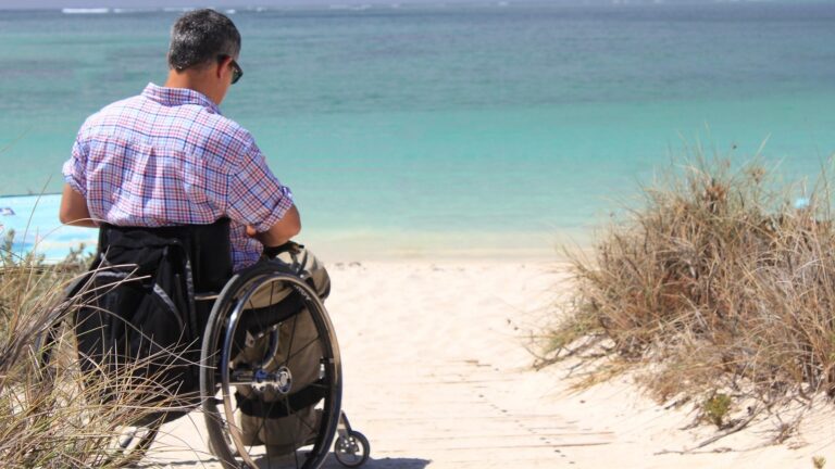 Person in wheelchair by the ocean, which he reached via handicap RV rental