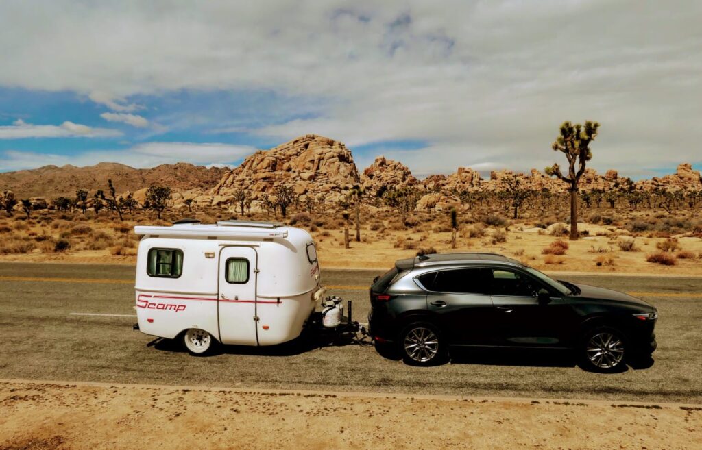 Cute mini RV hitched to trailer