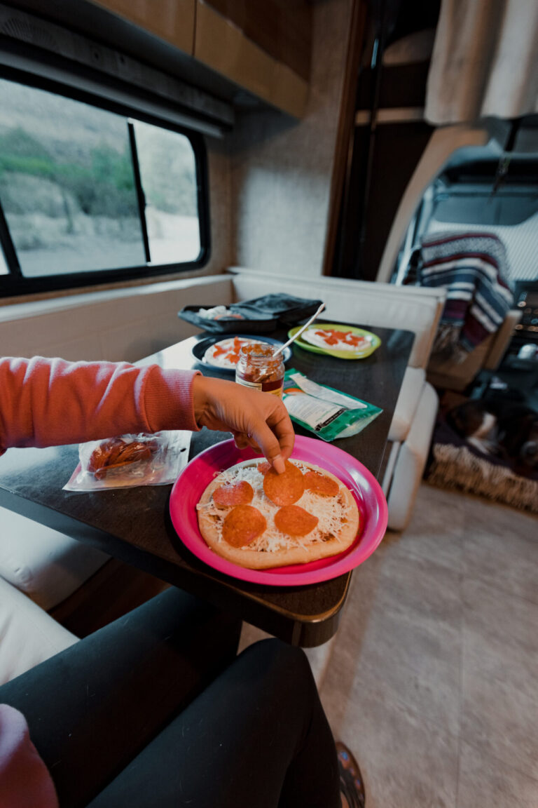a woman making a pizza in an RV