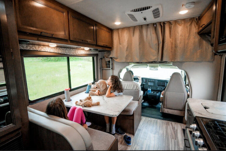 A family inside an RV looking out the window