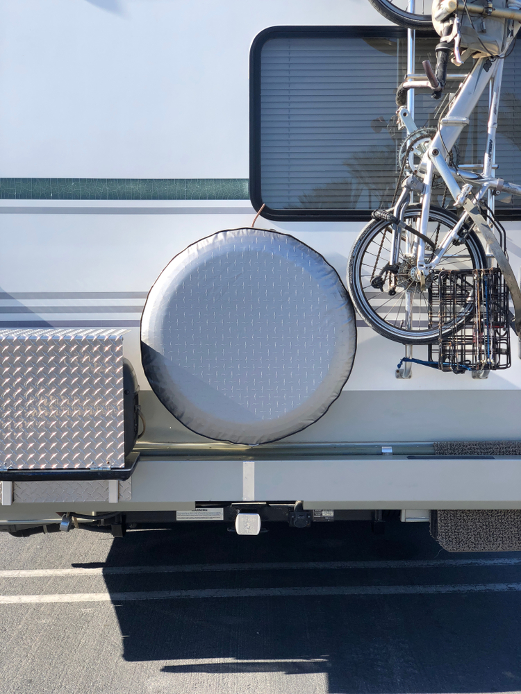 Covered spare tire on the back on an RV