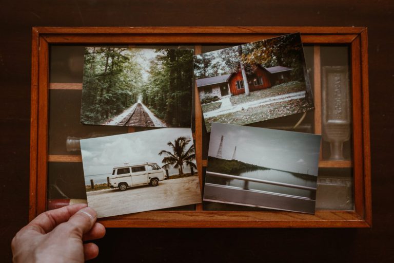 Collage of printed photos: an empty train track, a house, a camper van, and a lake