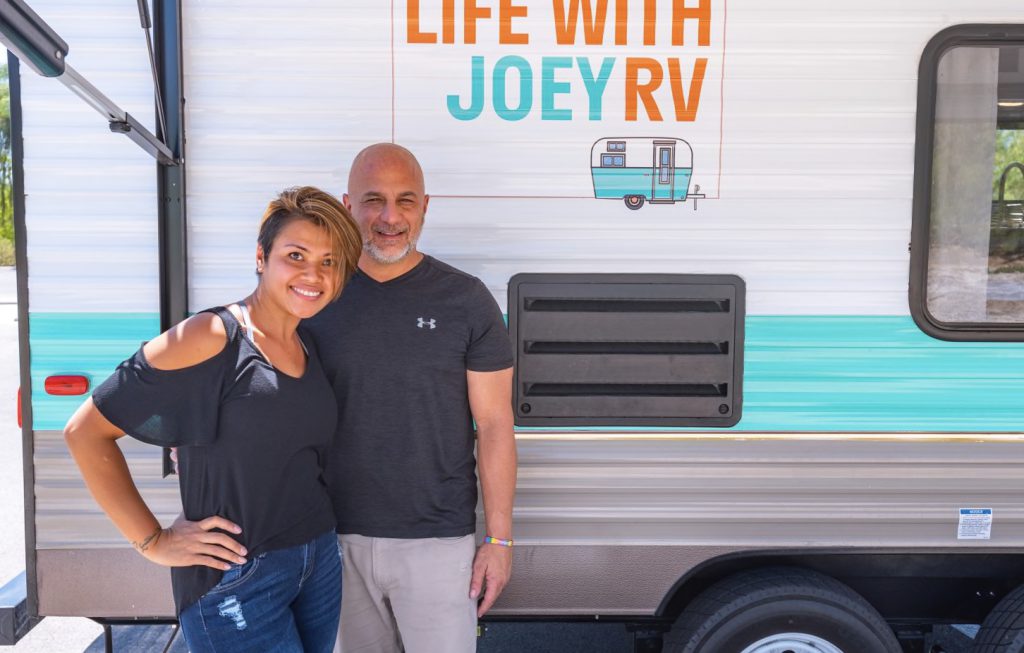 couple standing in front of their RV