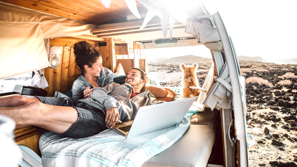 Young couple and their dog relax in campervan