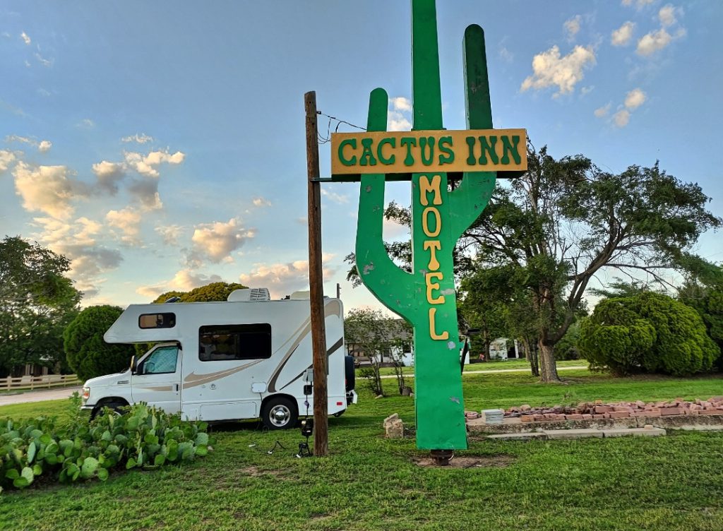 Class C RV parked next to a sign reading Cactus Inn