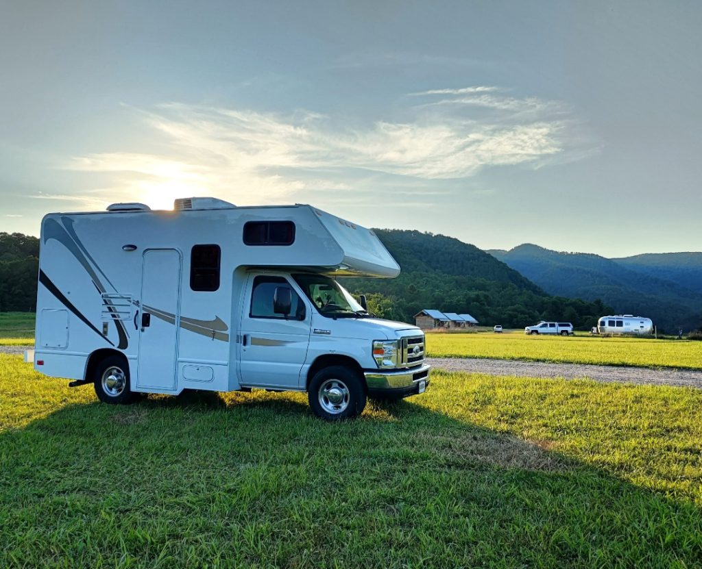 Class C RV parked in a grassy field