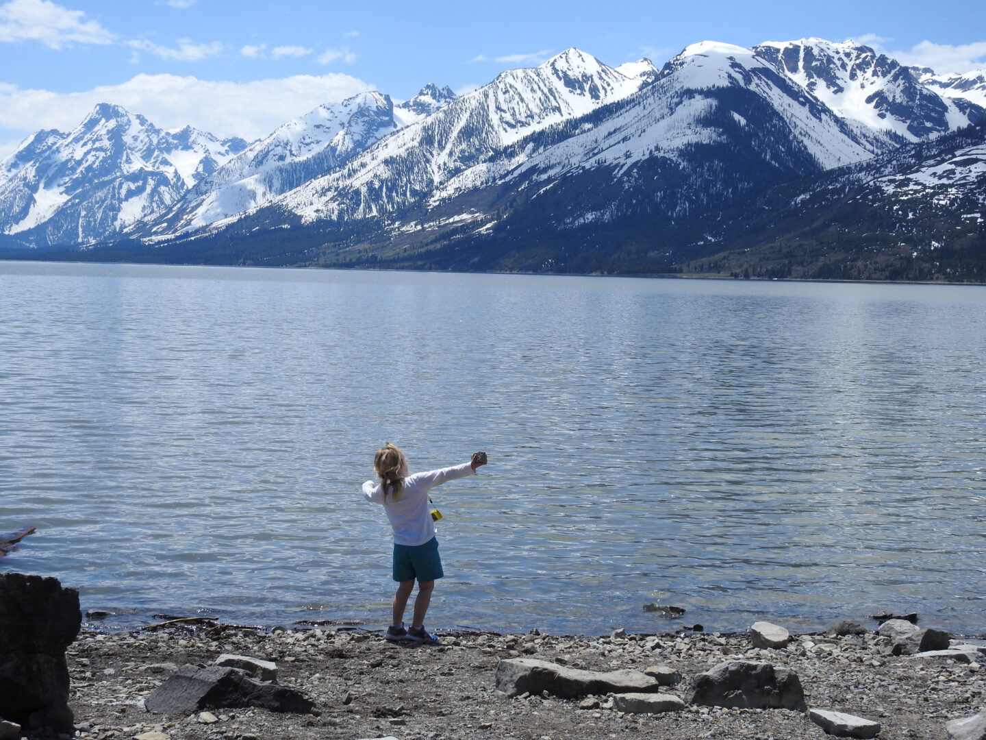 Child throwing a rock into Jackson Lake