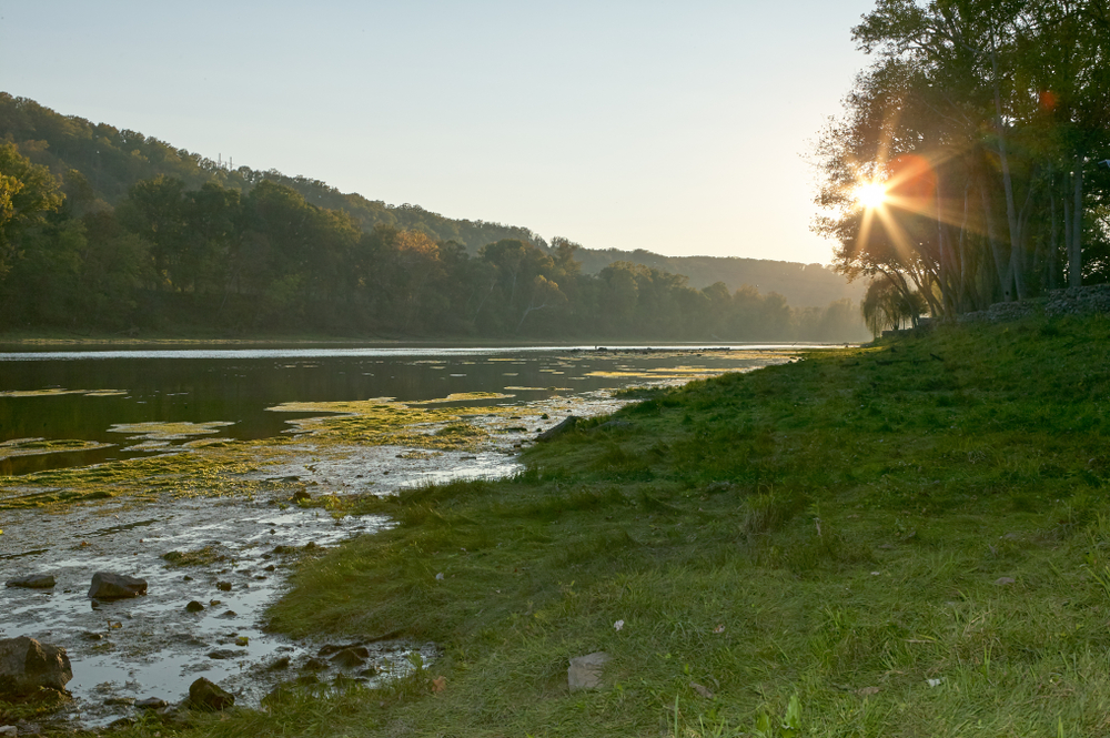 Star burst sun over the White River, Arkansas with early morning mist in a tranquil scenic landscape