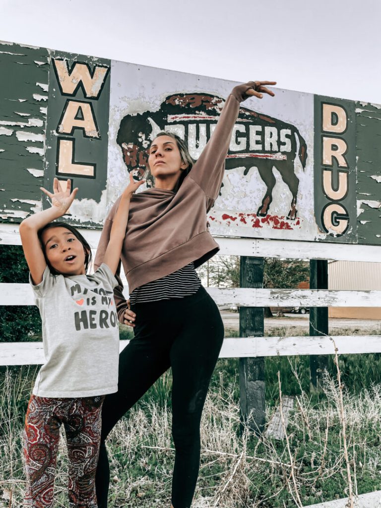 Mom and child pose in front of sign for Wall Drug