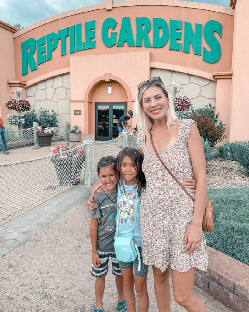 Mom and two children pose in front of Reptile Gardens