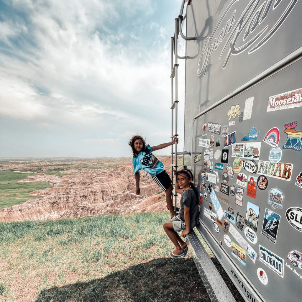 Child hangs off back ladder of an RV in Badlands NP