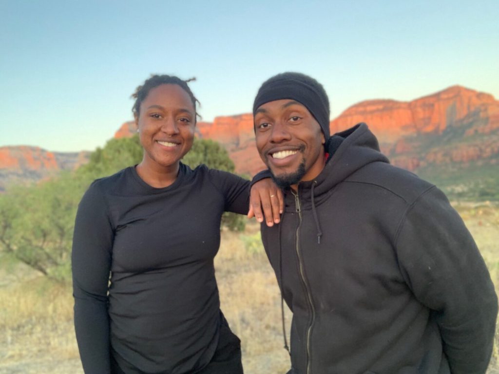 Couple smiles and poses together in a desert