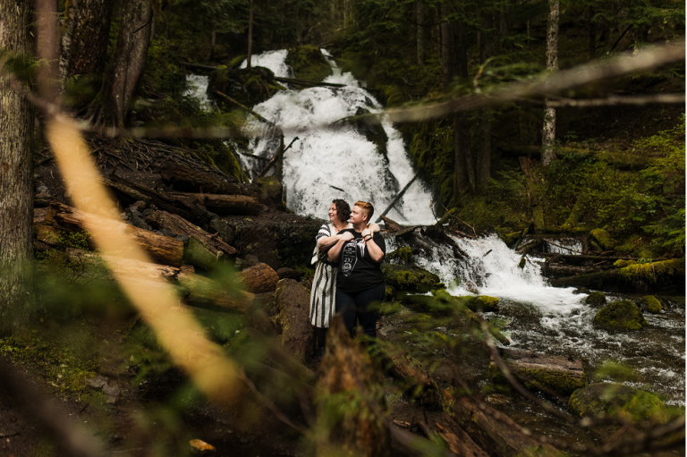 couple embraces at zigzag falls in oregon