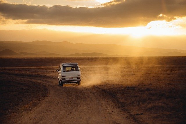 a campervan driving into the sunset