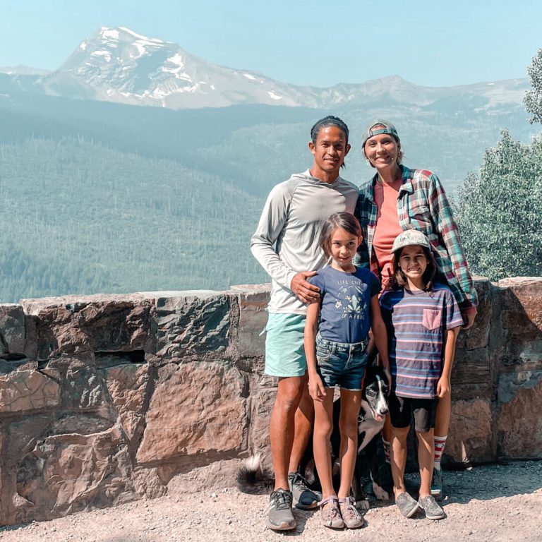 Family of four - mom, dad, son, daughter - poses at Glacier National Park