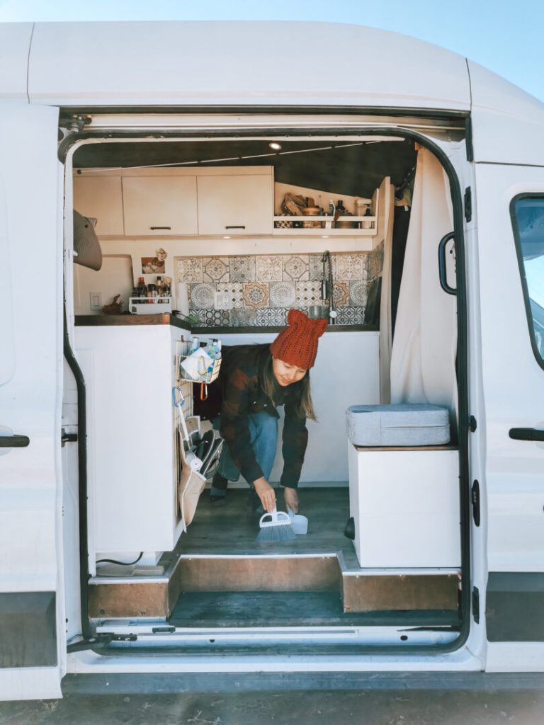 Woman cleans the inside of her campervan