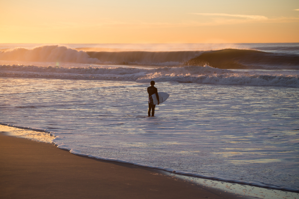 Surfer about to paddle out in high surf. Photographed in Rockaway Beach, Queens, New York, in October 2015.