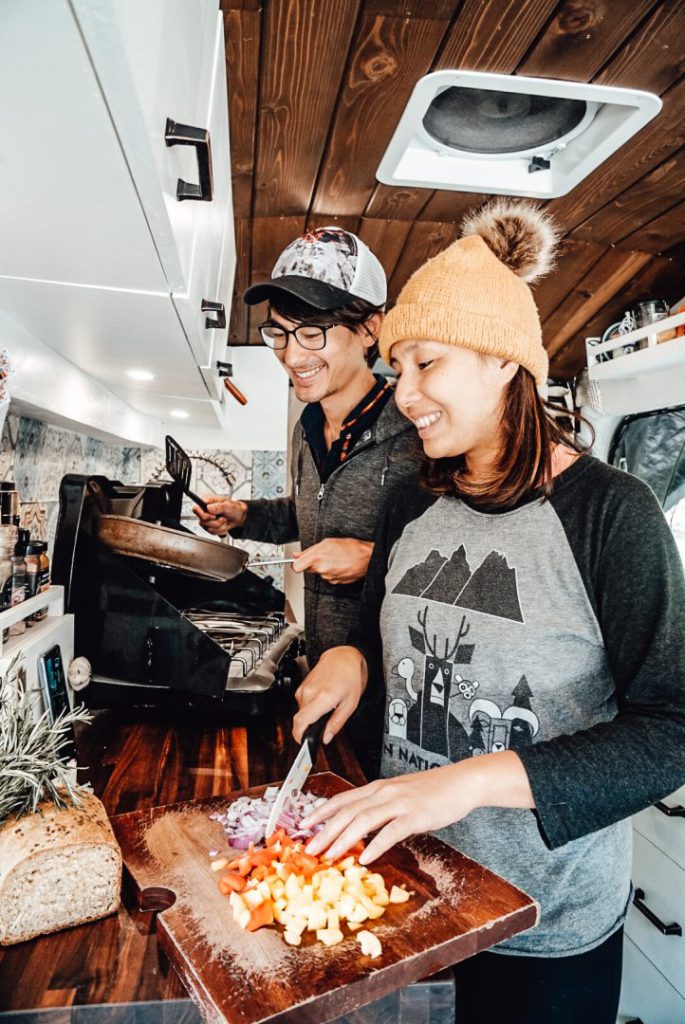 Young couple cooks together in their campervan