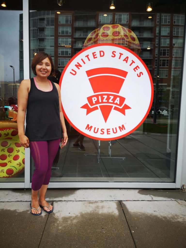 Woman stands outside United State Pizza Museum in Chicago