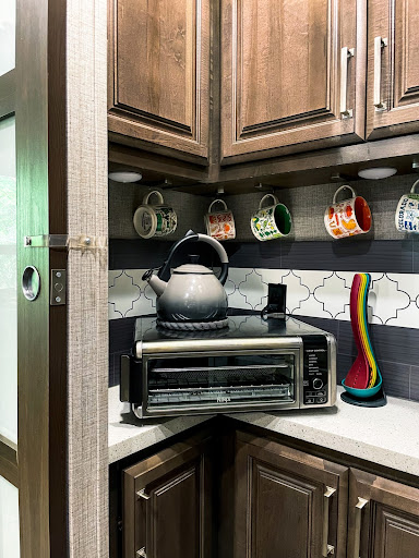 Toaster oven on counter of RV kitchen surrounded by colorful utensils and mugs