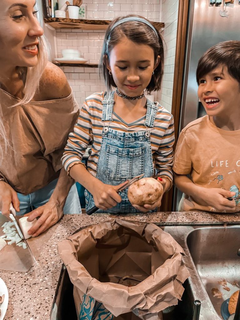 Mother chops vegetables with her two children