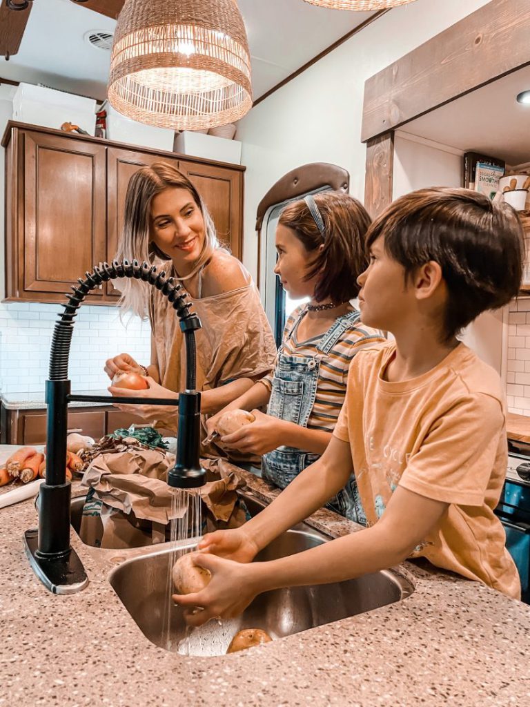 Kids help their mother chop vegetables in the kitchen