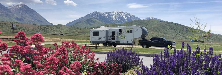 Parked fifth-wheel trailer with mountains in the background