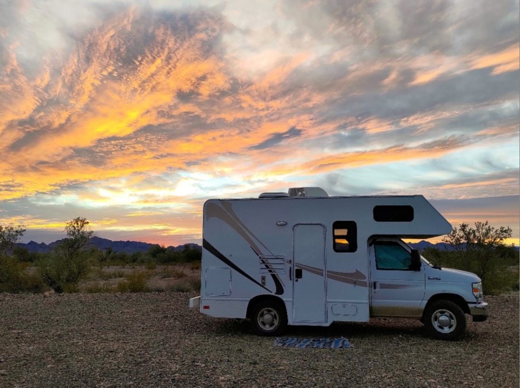 Class C RV parked at sunset