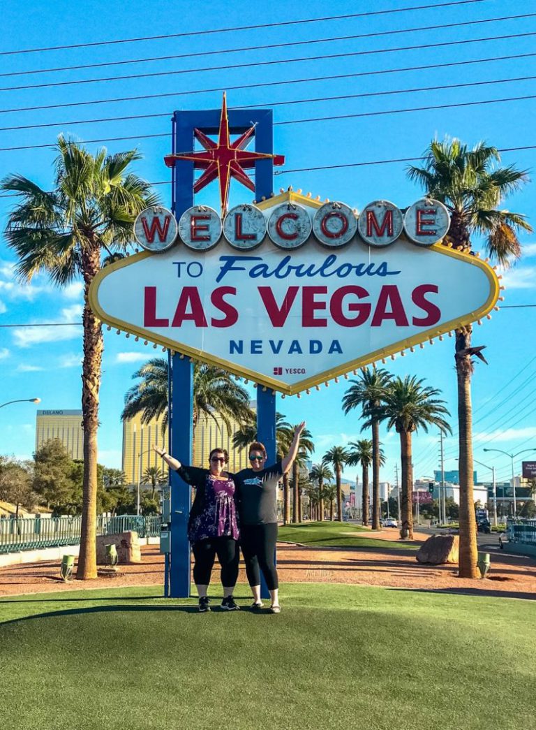 Couple poses in front of Welcome to Las Vegas sign