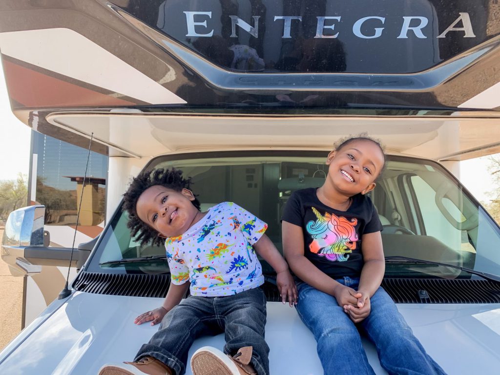 two kids sitting on an RV