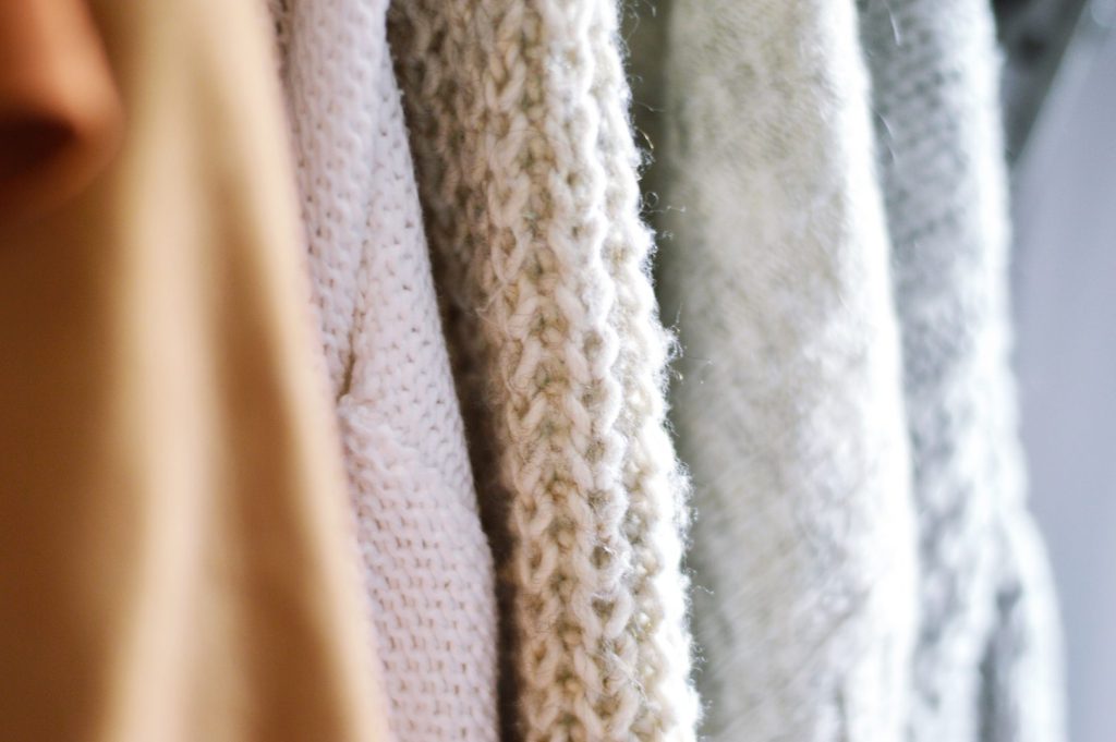 a close-up of sweaters hanging up drying