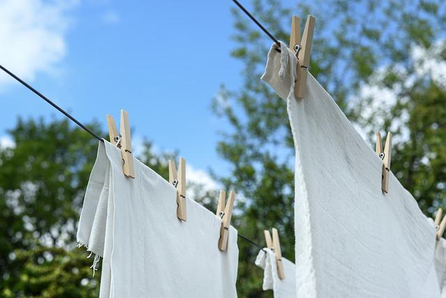 white linens drying on a clothesline under a blue sky