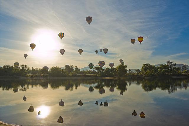 hot air balloons over a lake