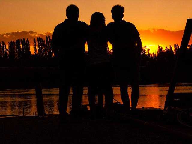 a family facing the sunset and embracing
