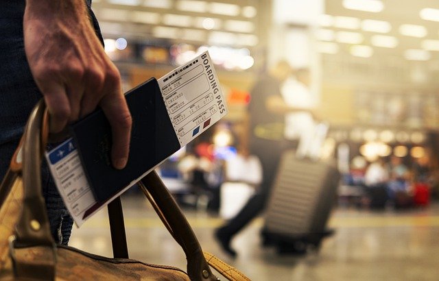 man with airplane boarding pass in hand