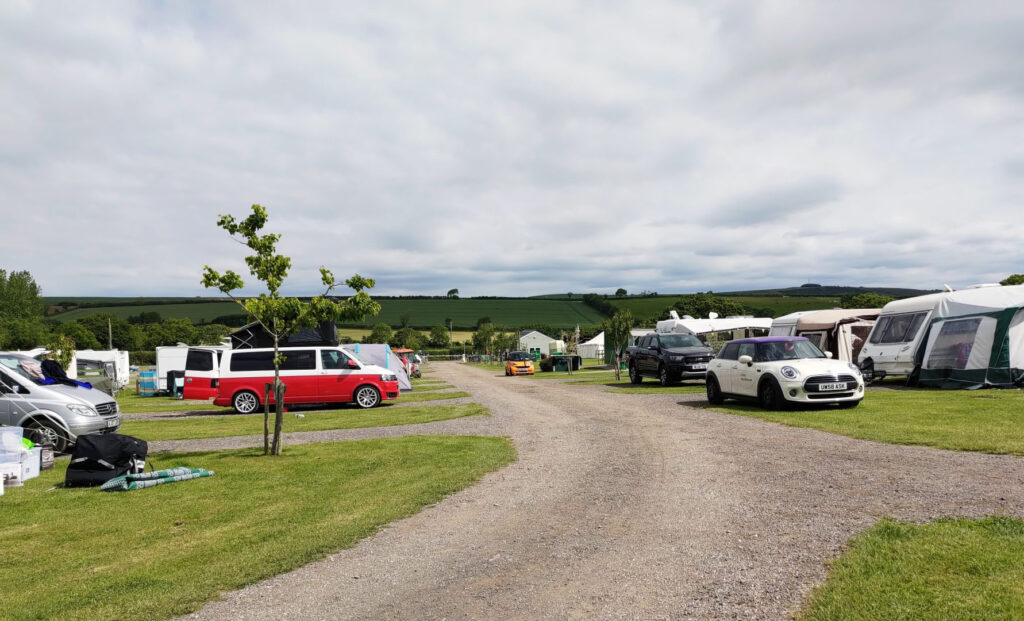 rvs and cars parked at a campground in england