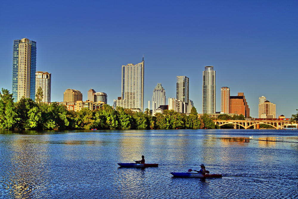 Kayakers in Lake Austin with the city skyline in the background