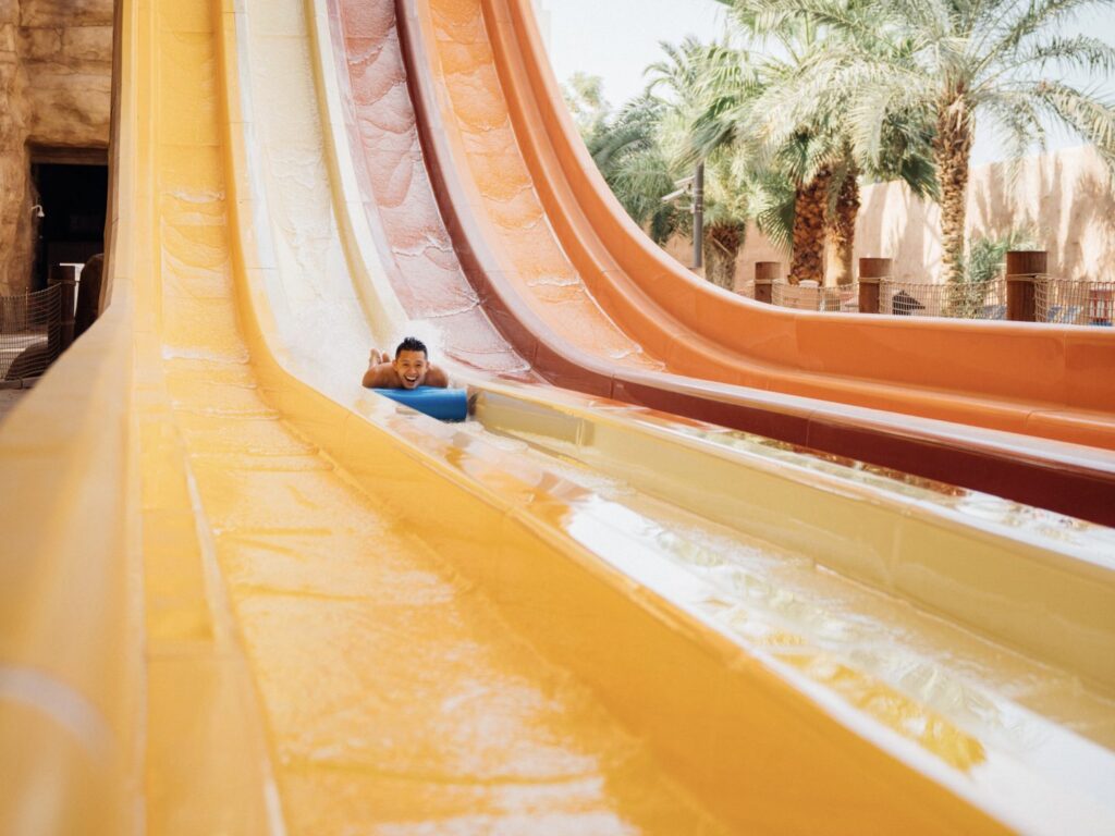 person travels down water slide face first